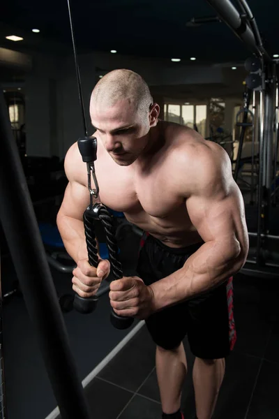 Bodybuilder doen zware oefening voor de Triceps met kabel — Stockfoto