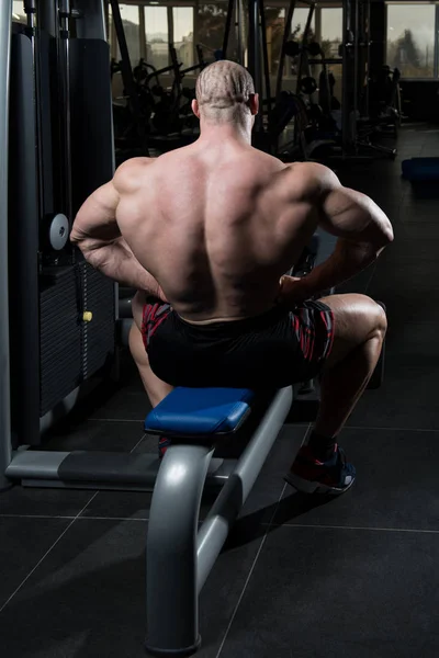 Seriöser Bodybuilder sitzt im Fitnessstudio — Stockfoto