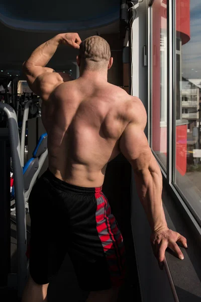 Stilig muskulös Man flexar muskler i gymmet — Stockfoto