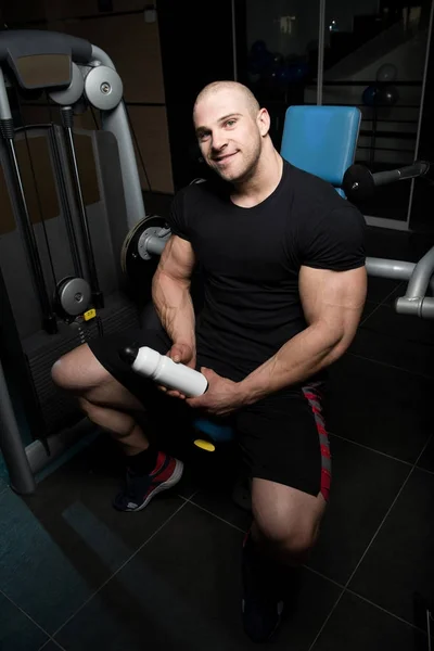 Bodybuilder trinkt Wasser aus Shaker — Stockfoto