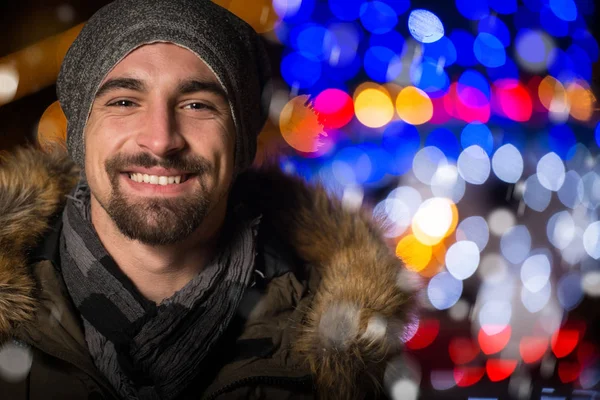 Веселый мужчина одет тепло на праздничном рынке — стоковое фото