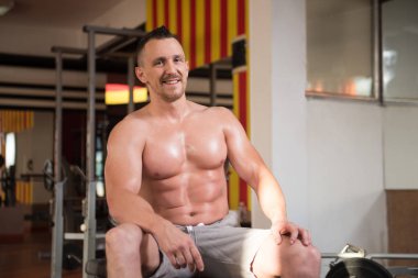 Yakışıklı ve çekici bir genç adam. Vücut kasları spor salonunda dinleniyor.