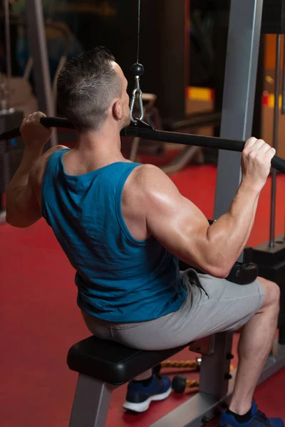 Guapo Culturista Haciendo Ejercicio Peso Pesado Para Volver Máquina Gimnasio — Foto de Stock