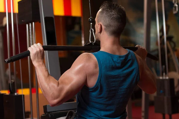 Stilig Idrottsman Gör Tung Vikt Övning För Baksidan Maskin Gymmet — Stockfoto