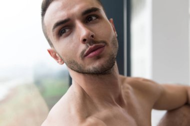 Spor salonu ve kasların esneme - güçlü ayakta sağlıklı genç adam kaslı atletik vücut Fitness Model çalışmaları sonra poz