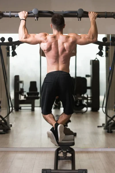 男子运动员做拉 Ups 引体向上在健身房里 — 图库照片