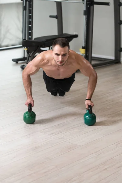 Zdrowy Człowiek Sportowiec Robi Pompki Trening Kettle Bell Siłowni Kettle — Zdjęcie stockowe