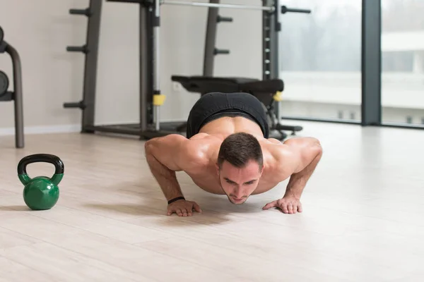 健美男子运动员在健身房用水壶铃做仰卧起坐锻炼 水壶铃运动 — 图库照片