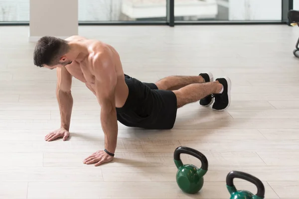 在一间健身房和肌肉伸缩 肌肉运动健美健身模型在地板伸展肌肉男 — 图库照片