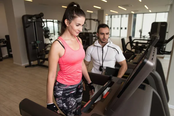 Personal Trainer Mostrando Giovane Donna Come Addestrare Aerobica Ellittica Walker — Foto Stock