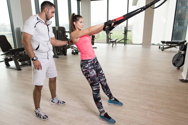 Personal Trainer Mostrando Giovane Donna Come Allenarsi Con Cinghie Fitness — Foto Stock
