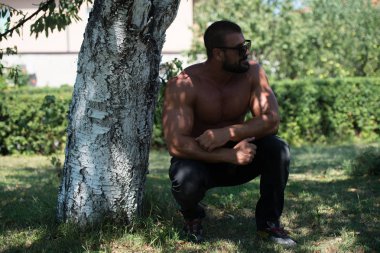 Doğada güçlü açık havada duran ve kasları - kaslı atletik vücut Fitness Model çalışmaları sonra poz esneme yakışıklı olgun adam