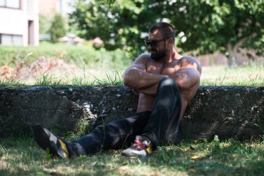 Doğada güçlü açık havada duran ve kasları - kaslı atletik vücut Fitness Model çalışmaları sonra poz esneme yakışıklı olgun adam