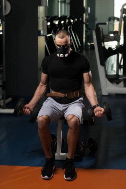 Pazı ayrıcalık maskeli Dumbbells ile egzersiz vücut geliştirmeci