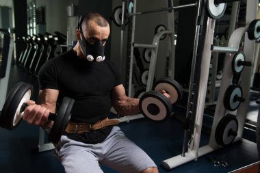 Pazı ayrıcalık maskeli Dumbbells ile egzersiz vücut geliştirmeci
