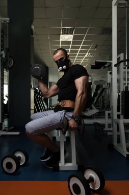Pazı ayrıcalık maskeli egzersiz Dumbbells ile adam