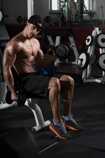 Biceps liikunta käsipainoilla kuntosalilla — kuvapankkivalokuva