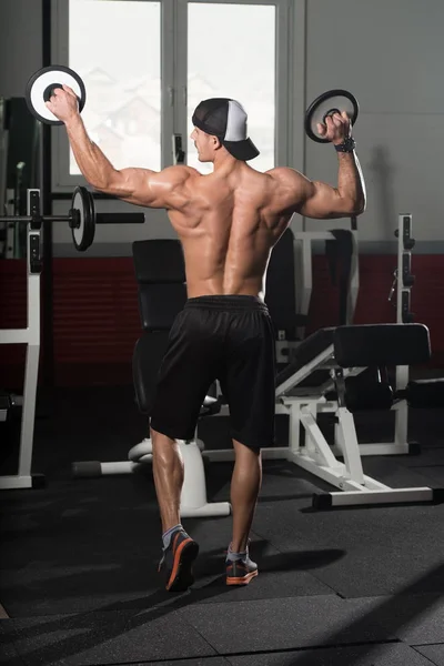 Culturista posando bíceps después de ejercicios con pesas — Foto de Stock