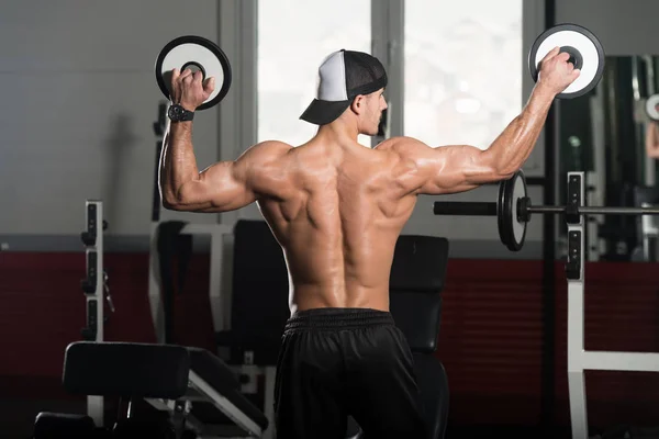 Muskulös Man flexar muskler med vikter — Stockfoto