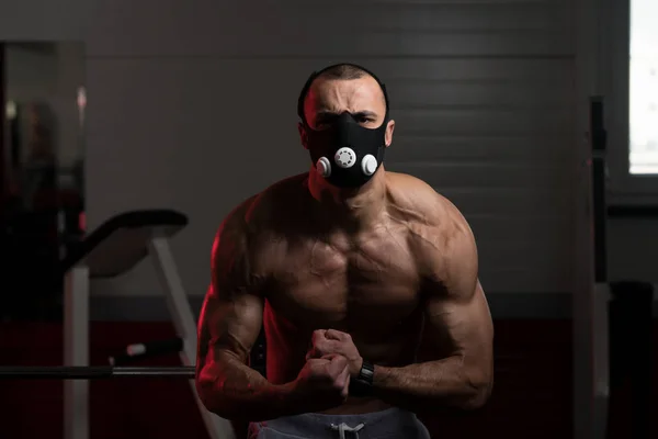 Bodybuilder die zich voordeed na oefeningen In hoogte masker — Stockfoto