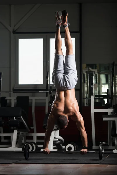 Atleta haciendo ejercicio push-ups en la barra en la máscara de elevación — Foto de Stock