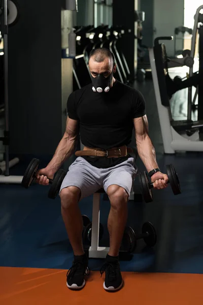 Bodybuilder uitoefening Biceps met halters In hoogte masker — Stockfoto