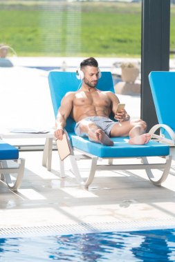 Adam güneşlenme üzerinde dinlenme ve müzik dinlemek