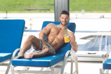 Bir bardak portakal suyu tutan ciddi adam