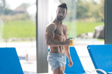 Bir bardak portakal suyu tutan ciddi adam