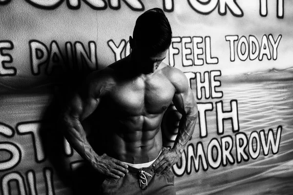 Man In Front Graffiti Wall Showing His Body — Stock Photo, Image