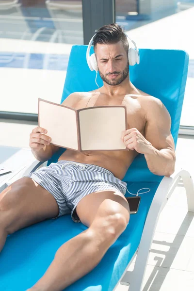 Hombre descansando en el sol Lounger y escuchar música —  Fotos de Stock