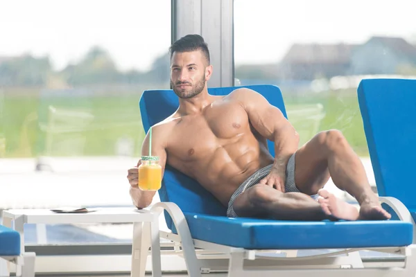 Hombre sosteniendo un vaso de jugo de naranja — Foto de Stock