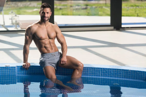 Jovem olhando o homem machista na piscina interior do hotel — Fotografia de Stock