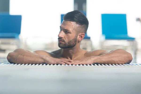 Nadador masculino descansando na piscina — Fotografia de Stock