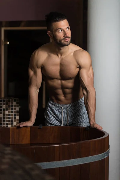 Muscular Man Flexing Muscles In Sauna