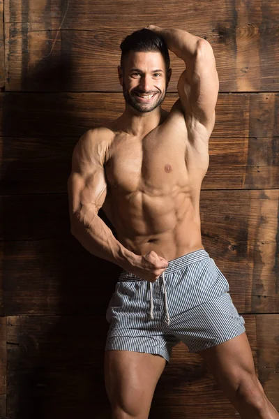Model Flexing Muscles Against the Wall — Stock Photo, Image