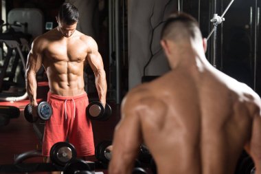 Pazı egzersiz bir spor salonunda Dumbbells ile