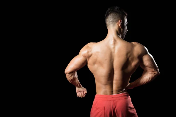 Jeune bodybuilder flexion muscles isoler sur noir Blackground — Photo