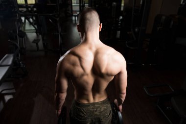 Ağırlıkları elinde tutan adam uygun