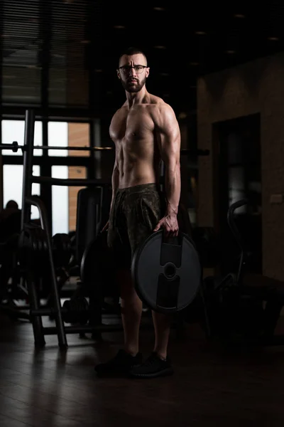 Geek Bodybuilder med vikter i handen — Stockfoto