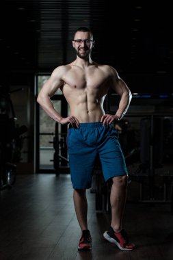 Kasların esneme gözlük takan genç vücut geliştirmeci