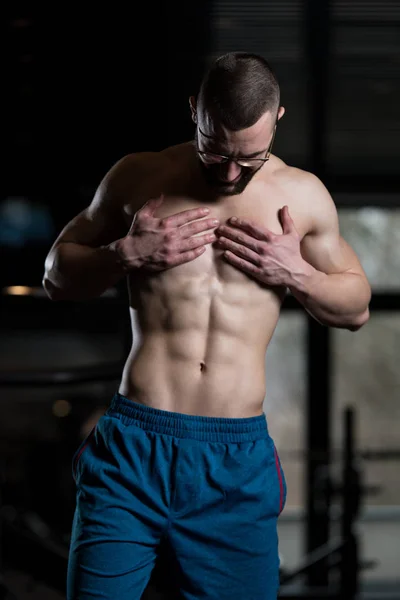 Muscoloso Geek uomo flessibile muscoli in palestra — Foto Stock
