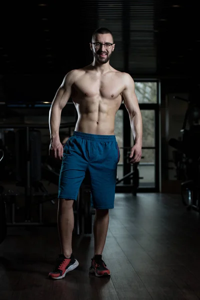 Homme Nerd debout fort dans la salle de gym — Photo