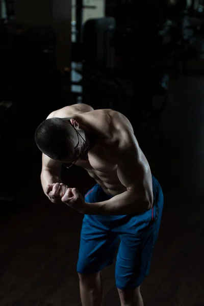 Nerd-Mann steht stark im Fitnessstudio — Stockfoto