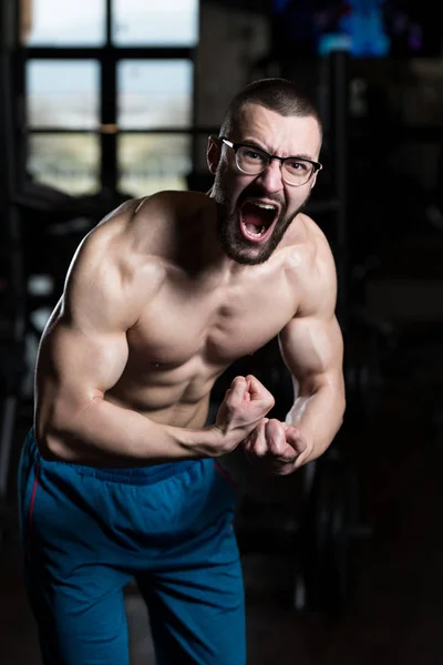 Gespierde Geek Man buigen spieren In sportschool — Stockfoto