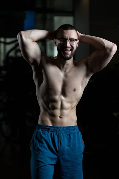 Nerd-Mann steht stark im Fitnessstudio — Stockfoto