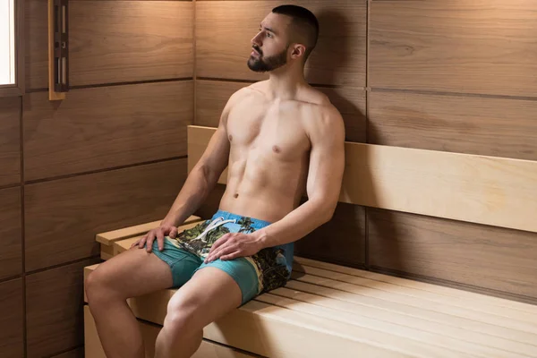 Retrato de un hombre musculoso relajándose en la sauna — Foto de Stock