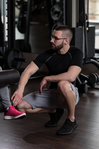 Benen van de trein van de vrouw op de Machine met Personal Trainer — Stockfoto