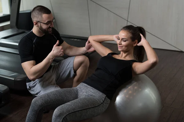 Kadın topu Abs egzersiz kişisel antrenör ile — Stok fotoğraf