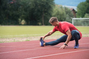 mâle coureur étirement avant l'entraînement